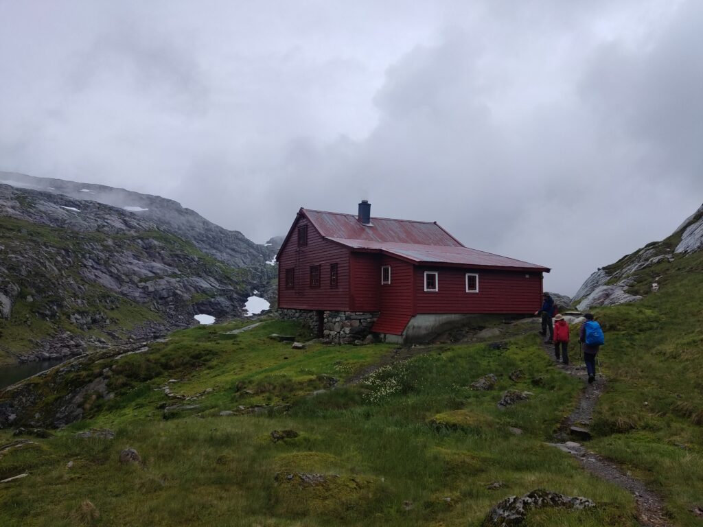 Høgabu, the wooden hiking hut, in a gray and rainy weather in the midst of the mountains.