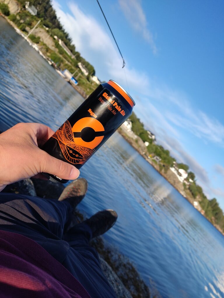 Me, sitting on a stone by the sea, with a beer in my hand, and a fishing rod next to me, enjoying life.
